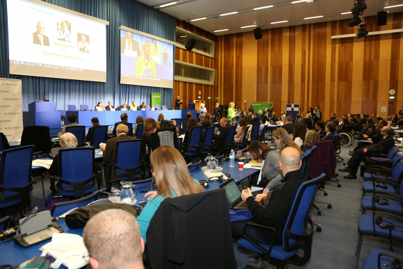 Podium einer Session der Konferenz mit Publikum